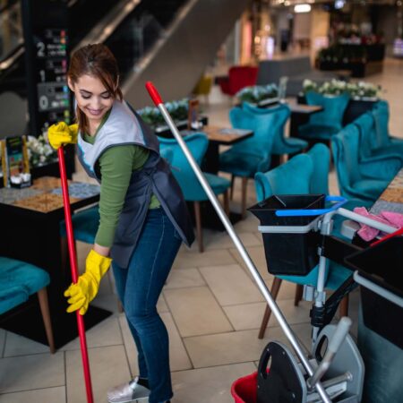 Beautiful young woman cleaning at shopping mall. Cleaning concept.
